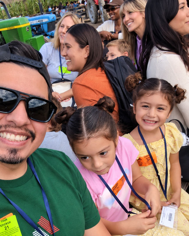 Family selfie with two smiling children and other visitors at the Tanaka Farms field trip.